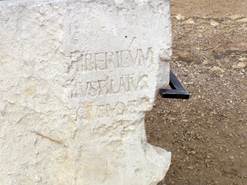 A stone with writing on it

Description automatically generated