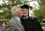 Proud grandfather kisses graduate.