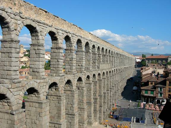 A long shot of a stone aqueduct

Description automatically generated